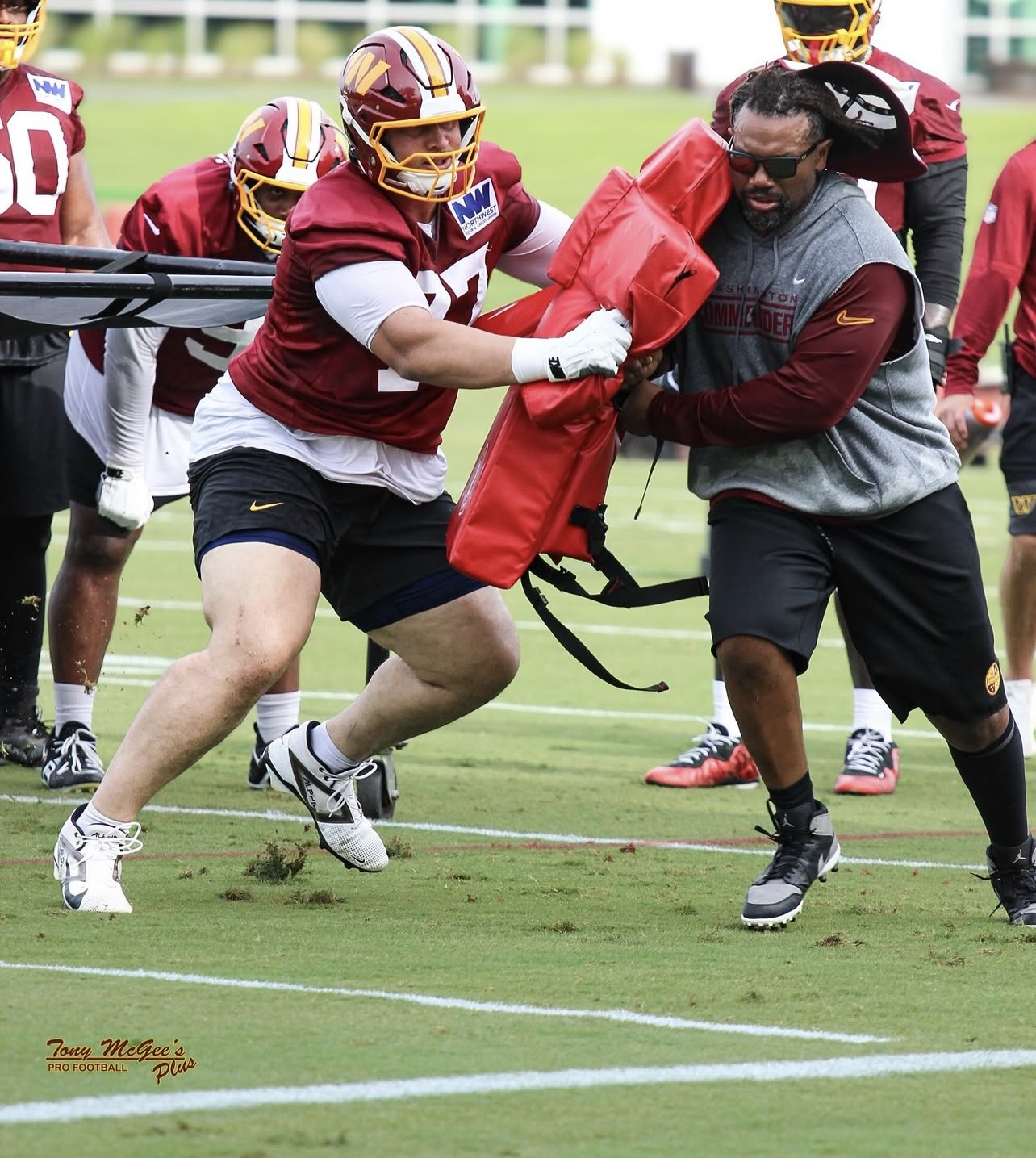 Coach working defensive line hand-fighting drills with a player